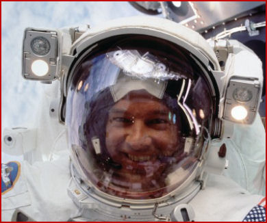 Jeff peers into the window of Atlantis's cabin while walking in space