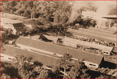 Los Banos internment camp from the air as liberation begins. Note smoke from markers for paratroopers.